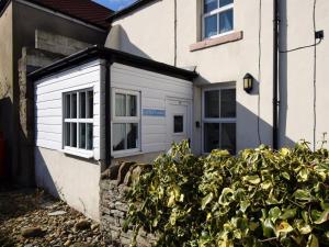 a white house with a bush in front of it at 1 Bed in Seahouses oc-cn123 in Seahouses