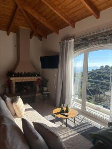 een woonkamer met een bank en een groot raam bij Ανέμη in Panayía