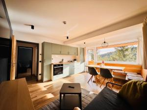 a kitchen and living room with a table and chairs at NORDIC Apartamente Păltiniș in Păltiniş