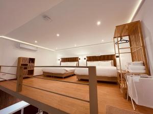 a bedroom with two beds and a wooden floor at Khao Lak - Loft Suite with 2 king size beds, bathroom with bathtub in Khao Lak