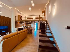 een woonkamer met een hoogslaper en een bank bij Khao Lak - Loft Suite with 2 king size beds, bathroom with bathtub in Khao Lak