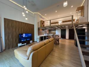 een woonkamer met een bank en een tv bij Khao Lak - Loft Suite with 2 king size beds, bathroom with bathtub in Khao Lak