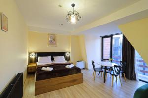 a bedroom with a bed and a table with chairs at Comfy Studio in Gudauri Marshall - By Wehost in Gudauri