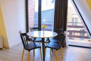 a table with chairs and a vase with flowers on it at Comfy Studio in Gudauri Marshall - By Wehost in Gudauri