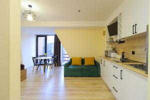 a kitchen with a green couch and a dining room at Comfy Studio in Gudauri Marshall - By Wehost in Gudauri