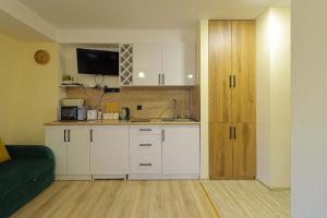 a kitchen with white cabinets and a couch in a room at Comfy Studio in Gudauri Marshall - By Wehost in Gudauri +33 photos