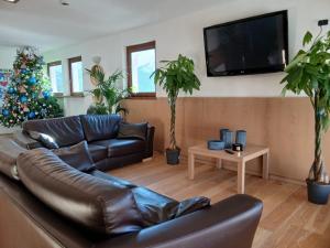 a living room with a leather couch and a christmas tree at Residence Cianfuran in Bardonecchia