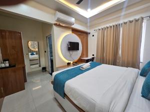 a bedroom with a large bed and a mirror at Hotel Sai Paradise in Lucknow +9 photos