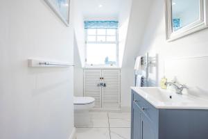 a bathroom with a toilet and a sink and a window at Overton - Elie in Elie +77 photos