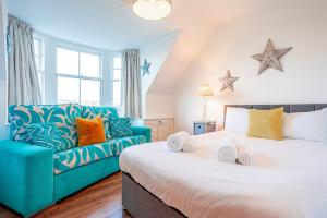 a bedroom with a large bed and a blue couch at Overton - Elie in Elie
