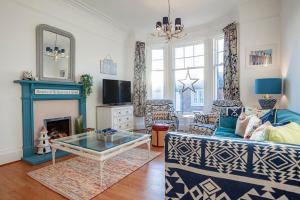 a living room with a couch and a fireplace at Overton - Elie in Elie