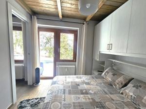 a bedroom with a bed and a large window at Moda Apartments G1 in Sestriere