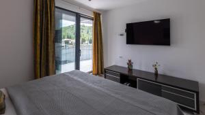 a bedroom with a bed and a flat screen tv at Villa Juma by Villas Guide in Blace