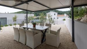 a patio with a table and chairs under a roof at Villa Juma by Villas Guide in Blace