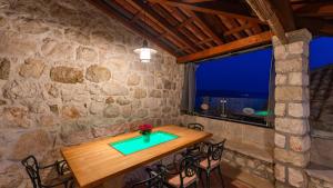 een tafel in een kamer met een stenen muur bij Villa Dia by Villas Guide in Dubrovnik