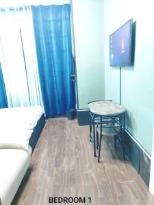 een kamer met een tafel, een bank en een tv bij FARISHTAs house two bedroom apartment in Corsico +2 foto's