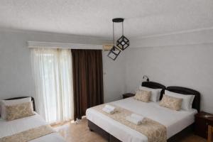 een hotelkamer met twee bedden en een raam bij Porto Matina in Metamorfosi