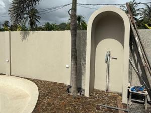 een muur met een boog naast een palmboom bij ZENARA lombok in Kuta Lombok +5 foto's