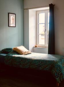 a bedroom with a bed with a window and a bedspread at Grande maison de ville MALO LEONE 250m2 pour 15 personnes proche du Puy du Fou in Mauléon