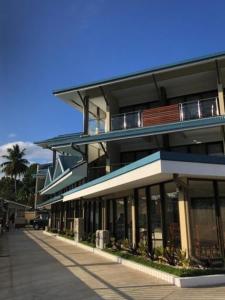 a large building with a balcony on a street at Nambis Inn in Madang
