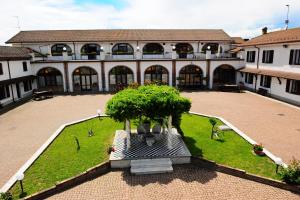 a courtyard with a large building with a tree in it at Il Carrettino Country Hotel in Tortona
