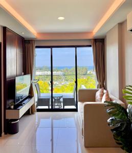 a living room with a couch and a television at Surin Beach View Phuket in Ban Lum Fuang