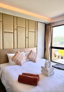 a hotel room with a bed with towels on it at Surin Beach View Phuket in Ban Lum Fuang +58 photos