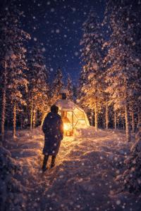 een persoon die over een met sneeuw bedekt pad loopt met een prieel bij Aurora Igloo Village Ylläs Luna Suite - Hot Tub in Ylläsjärvi