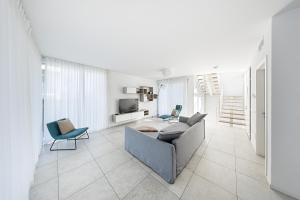 un soggiorno bianco con divano e sedie di I Tesori di Minerva by Whale Homes a Manerba del Garda