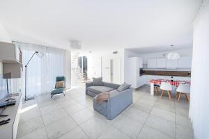 un soggiorno con un divano e un tavolo con sedie di I Tesori di Minerva by Whale Homes a Manerba del Garda