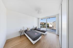 una camera da letto con due letti e una grande finestra di I Tesori di Minerva by Whale Homes a Manerba del Garda Altre 35 foto