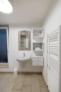 un bagno bianco con lavandino e specchio di I Tesori di Minerva by Whale Homes a Manerba del Garda