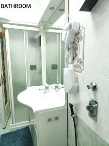 een badkamer met een wastafel en een douche bij FARISHTAs house two bedroom apartment in Corsico