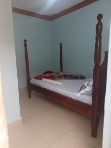 een bed met een houten frame in een kamer bij Delight motel in Ishaka