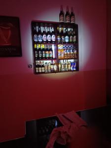een muur met een rek vol alcoholflessen erop bij Delight motel in Ishaka