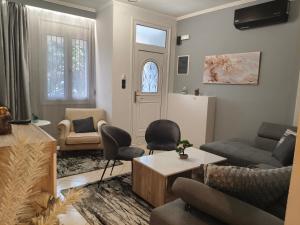 a living room with a couch and chairs and a door at Xryspa suites in Ioannina