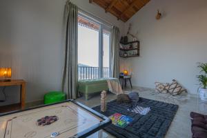 a living room with a pool table and a large window at SaffronStays The Kumaoni Abode in Bhīm Tāl +20 photos