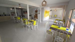 een eetkamer met gele tafels en stoelen bij Pousada Sal e Mar Maracaipe in Porto De Galinhas