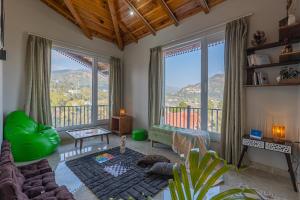 a living room with a view of a mountain at SaffronStays The Kumaoni Abode in Bhīm Tāl