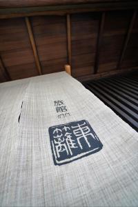 a bed with a blanket with writing on it at Ryokan Tori in Kyoto