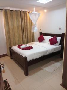 een slaapkamer met een groot bed met rode kussens bij Keriwest hotel in Kericho