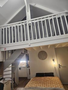 a bedroom with a bed under a staircase at Le Ptit nid in Château-Gontier