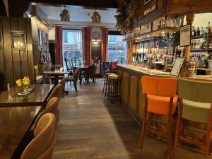 a restaurant with a bar and tables and chairs at Great Malvern Hotel in Great Malvern +7 photos