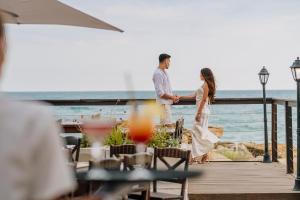 a bride and groom standing on a deck overlooking the ocean at HVD Nympha Hotel - Adults Only - Private Beach & Free Parking in Golden Sands
