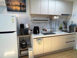 a small kitchen with a sink and a refrigerator at Miru House in Seogwipo +4 photos