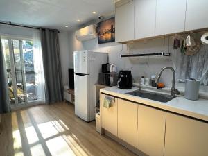 a kitchen with a white refrigerator and a sink at Miru House in Seogwipo