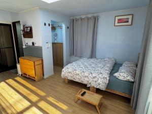 a small bedroom with a bed and a table at Miru House in Seogwipo
