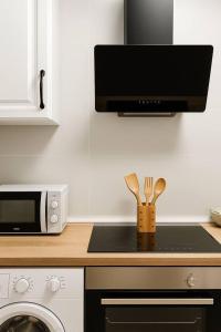 a kitchen with a counter top with a microwave and utensils at Alojamiento Baeza California 4B in Baeza +23 photos