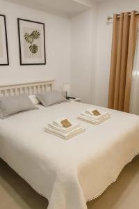 a white bed with two pillows on top of it at Alojamiento Baeza California 4B in Baeza