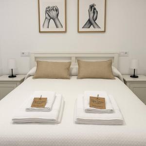 een wit bed met twee handdoeken erop bij Alojamiento Baeza California 4A in Baeza